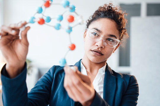 Businesswoman examining molecular structure in office