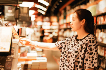 A woman browsing books in a well-lit bookstore