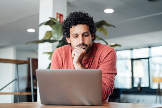 Businessman working on laptop at desk in office