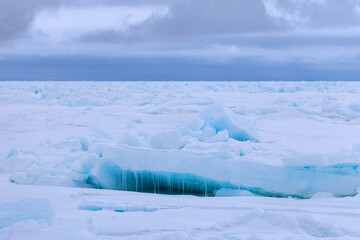 Blue light reflections and icicle n the arctic ice north of Svalbard, Norway © Reto Ammann