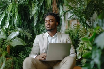 Young man sitting in a green office, working on his laptop, demonstrating the modern trend of remote work and the flexibility of working in a sustainable, eco-friendly environment, Generative AI