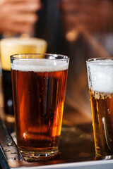Glasses of different shades of beer on bar top