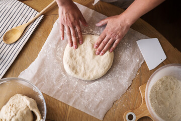 Female hands rolling dough, home baking