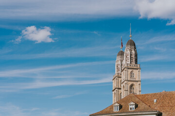 Fraumunster church towers rising above zurich skyline under blue sky
