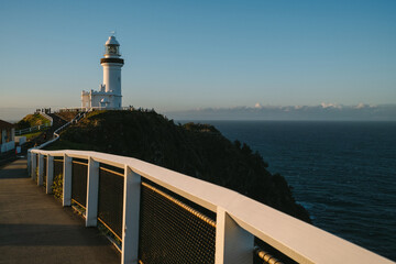 Lighthouse on cliffside at Byron Bay during golden sunset.