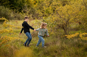 Kids playing tug of hands in nature.
