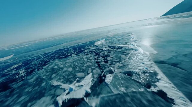 Skimming low across a vast icy lake with stunning clear ice patterns
