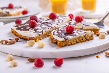 Homemade flat carrot cake with nuts, iced with cream cheese and carrot juice