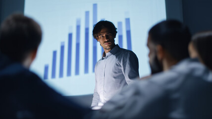 Businessman presenting financial data to diverse team, discussing economic risk and credit analysis in modern office