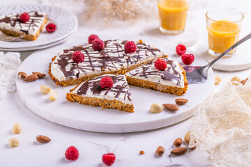 Homemade flat carrot cake with nuts, iced with cream cheese and carrot juice