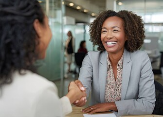 Positive vibes successful businesswoman celebrates new job in a modern office with a handshake