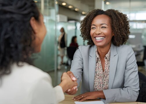 Positive vibes successful businesswoman celebrates new job in a modern office with a handshake