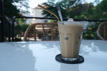 Iced Cafe Latte with Metal Straw on Outdoor Table