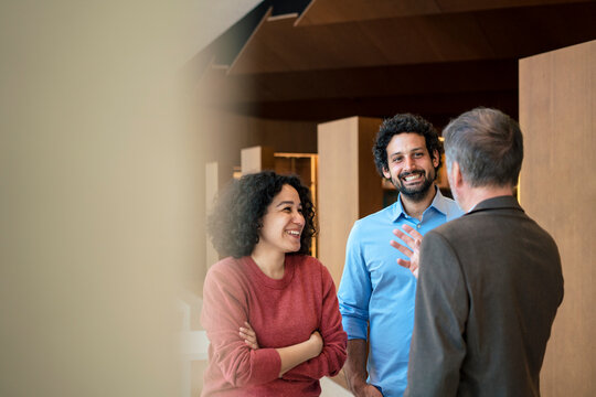Happy multiracial colleagues discussing in office