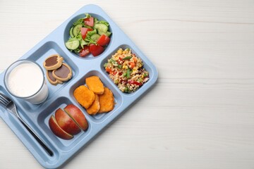 School lunch. Plastic tray with tasty food, milk and fork on white wooden table, top view. Space for text