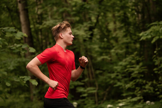young boy running cross country in summer forest