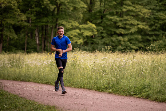 young boy running cross country in summer forest