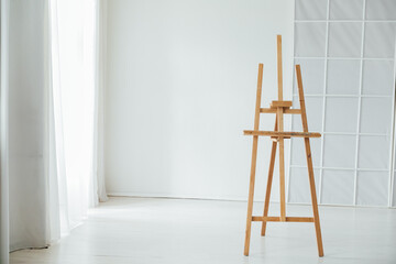 Easel in the interior of an empty room with a window
