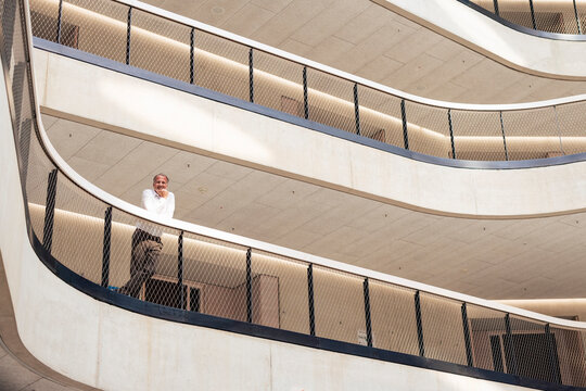 Senior businessman leaning on railing in corridor
