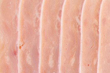 Slices of ham, thinly sliced sausage. Ham texture background. Close-up, top view.