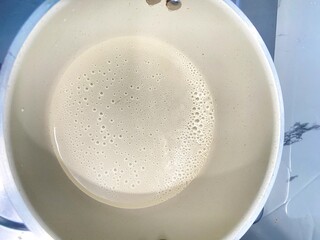 Creamy Milk Bubbles in Saucepan, Top View