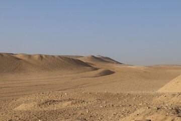 Vast desert landscape with rolling sand dunes.