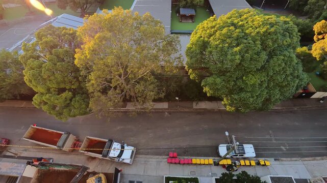 Timelapse of a busy neighborhood street with cars passing by and a truck carrying earth from nearby construction