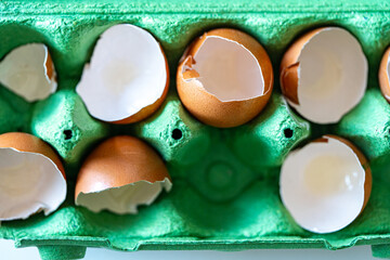 Eggshells in the cells of a green egg carton. Close-up.