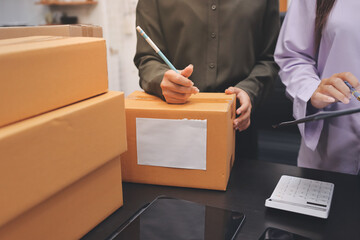Portrait of Starting small businesses SME owners, two Asian woman check online orders Selling products working with boxs freelance work at home office, sme business online small medium enterprise