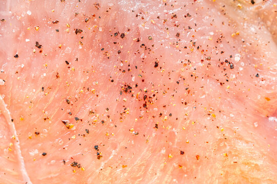 Raw chicken fillet marinated with seasonings close-up. Background with the texture of raw chicken meat. The process of making cordon bleu.