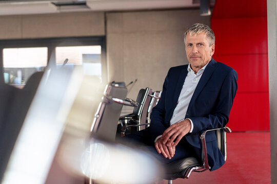 Senior businessman sitting on chair in meeting room at office