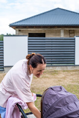 young mother with a stroller doing her daily chores near her private house