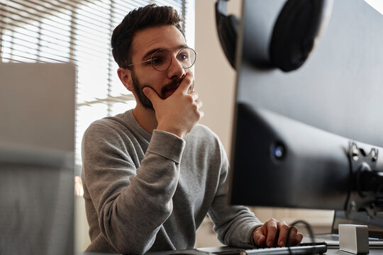 Thoughtful IT professional working on computer