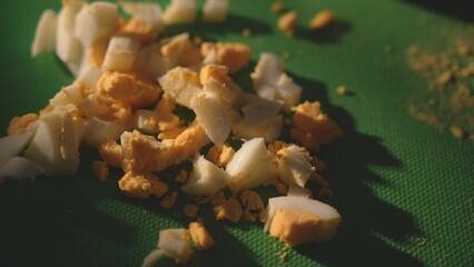 Sliced boiled egg on green cutting board