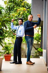Indian business professionals with tablet collaborating outside modern corporate building