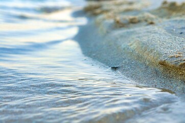 Shallow Ocean Waves at Sunset with Golden Reflections