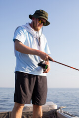 fisherman fishing, Fishing rod, spinning, fisherman against blue sky