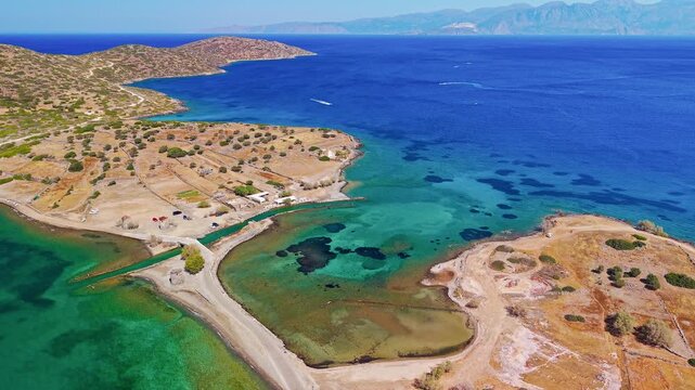 Aerial view of the causeway, town, and blue Aegean Sea at Elounda, Crete.