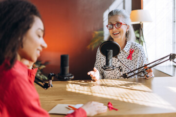 Radio host interviewing guest about breast cancer awareness in recording studio