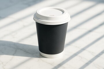 Black paper coffee cup with white lid standing on bright marble surface with shadows, minimal mockup for branding and product presentation. Ai generative