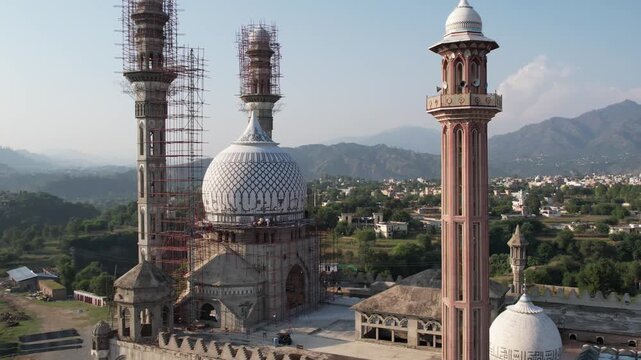 Drone shot of a large mosque under construction in Kolti, Azad Kashmir, nestled amidst rolling hills. Gulhar sharif mosque.