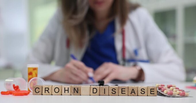 Medical professional works with papers by cubes with Crohn Disease and pills. Clinical setting for diagnosis and treatment of Crohn disease in clinic