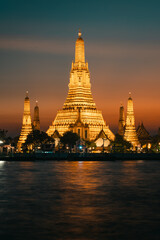 Fototapeta premium Wat Arun Temple Illuminated at Sunset — Bangkok Riverside View
