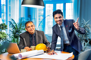 Indian architects collaborate on creative blueprints and interior layouts in stylish office setting