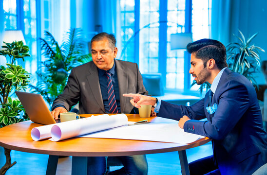 Indian architects collaborate on creative blueprints and interior layouts in stylish office setting