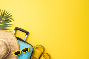Travel essentials for summer on vibrant yellow background including sunglasses, hat, and suitcase