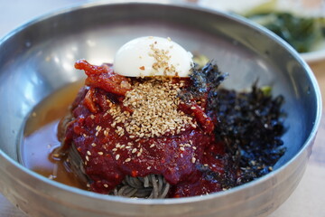 Close-up of Korean Buckwheat Noodles with Braised Pollack in Metal Bowl
