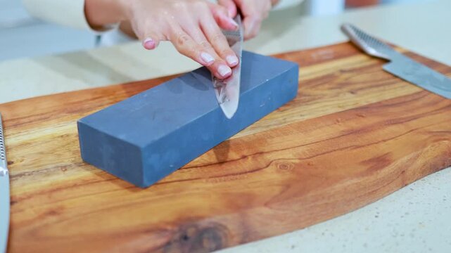 Sharpening Kitchen Knife on Whetstone in Bright Kitchen