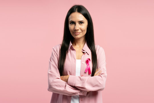 Beautiful Latin woman wearing pink ribbon showing support for breast cancer awareness - Powered by Adobe