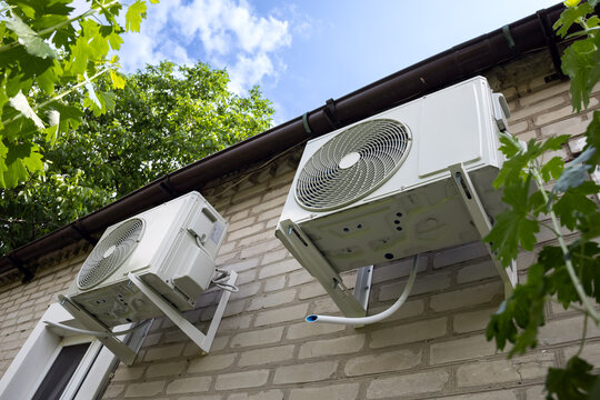 Outdoor two split air conditioning units mounted on siding wall